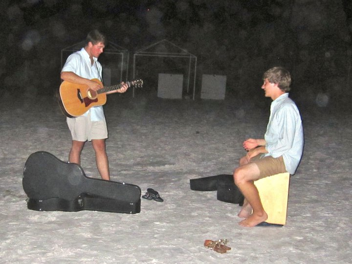 Listening to performers on the beach.